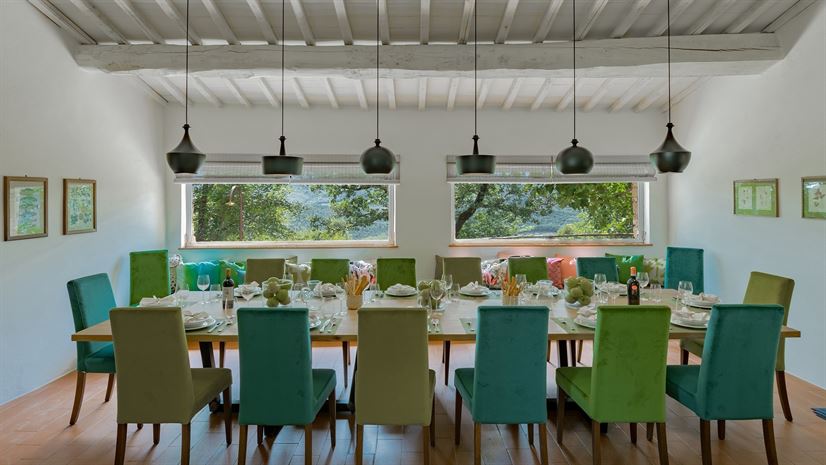 The villa's dining room, one long table under chandeliers